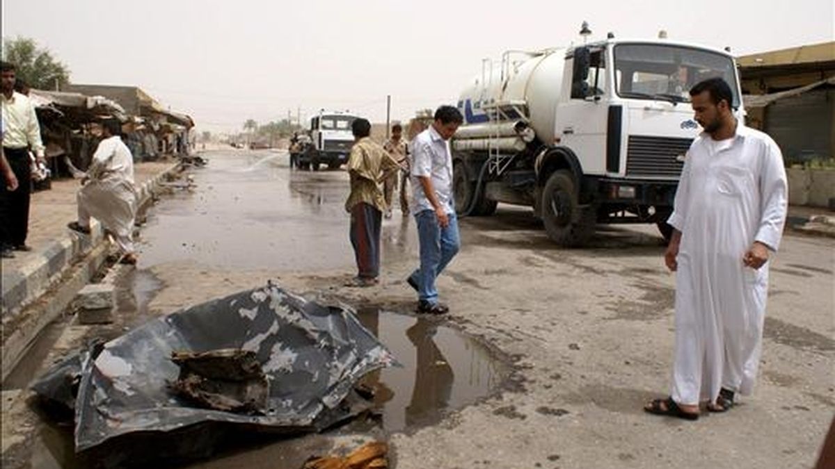 Varios iraquíes inspeccionan los restos de un coche utilizado en un atentado en Nasriya, al sur de Irak hoy miércoles 10 de junio de 2009. Al menos 32 personas han muerto y 47 han resultado heridas tras la explosión de un coche bomba en un mercado de la ciudad sureña iraquí de Nasriya.EFE