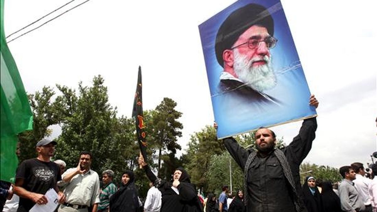 Un grupo de iraníes con retratos delayatolá Alí Jameneí grita consignas durante la oración de los viernes en Teherán (Irán), hoy 19 de junio. Jameneí hizo hoy un llamamiento a la calma y pidió el fin de las manifestaciones en las calles con las que la oposición protesta por las elecciones del pasado día 12, a las que considera fraudulentas. EFE