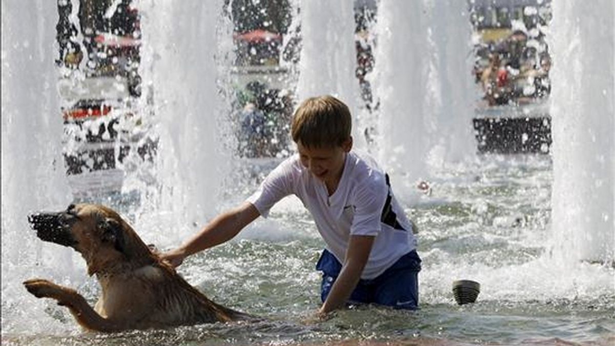 Un niño disfruta refrescándose junto a su perro en una fuente en Podolsk a unos 16 km de Moscú en Rusia el sábado, 17 de julio. Una ola de calor está cubriendo Rusia donde se están alcanzando temperaturas récord de 37 grados. EFE/Archivo
