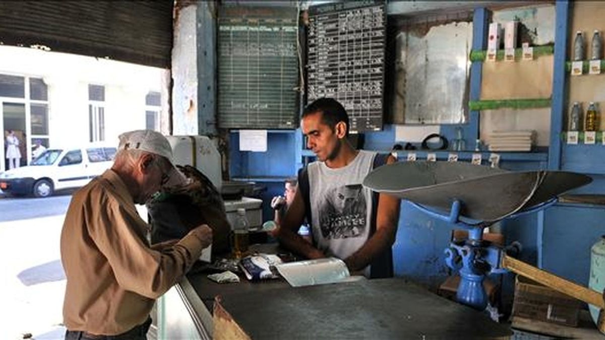 Un bodeguero vende productos racionados a un cliente en La Habana (Cuba). EFE