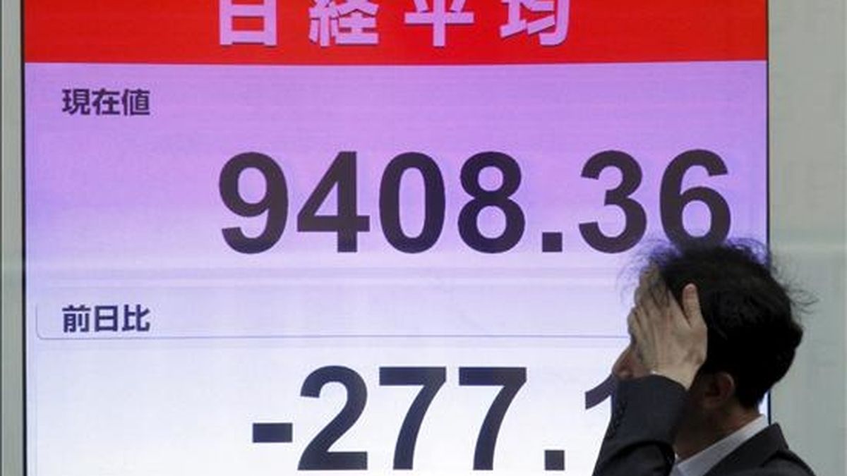 Un empresario pasa junto a una pantalla con los resultados de la Bolsa de Tokio (Japón). EFE/Archivo