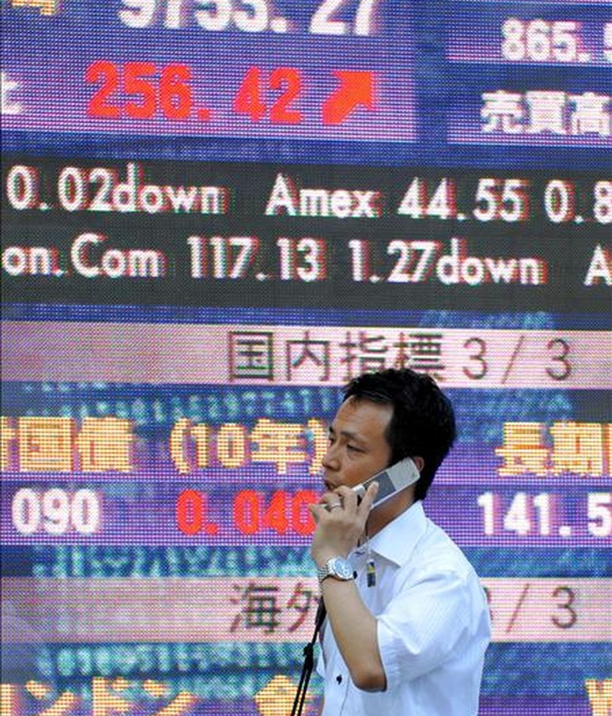Un ejecutivo japonés camina frente a un tablero electrónico con los índices de la Bolsa de Tokio, Japón. EFE/Archivo