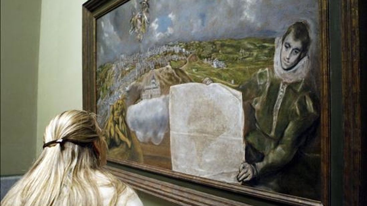 Una mujer observa el cuadro "Vista y plano de Toledo", de El Greco, procedente del museo dedicado al pintor en la capital castellano-manchega, que ha sido instalado hoy en una de las salas del museo del Prado de Madrid. EFE