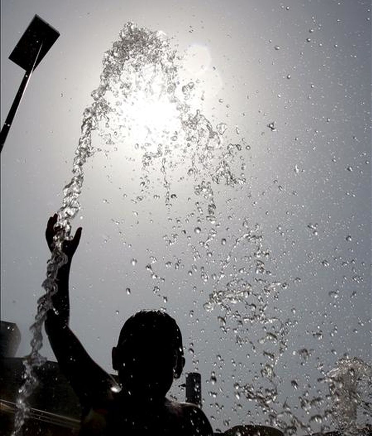 Un niño juega con el chorro de agua de una fuente de Bilbao, para aliviar la ola de calor que azota toda la peninsula. EFE