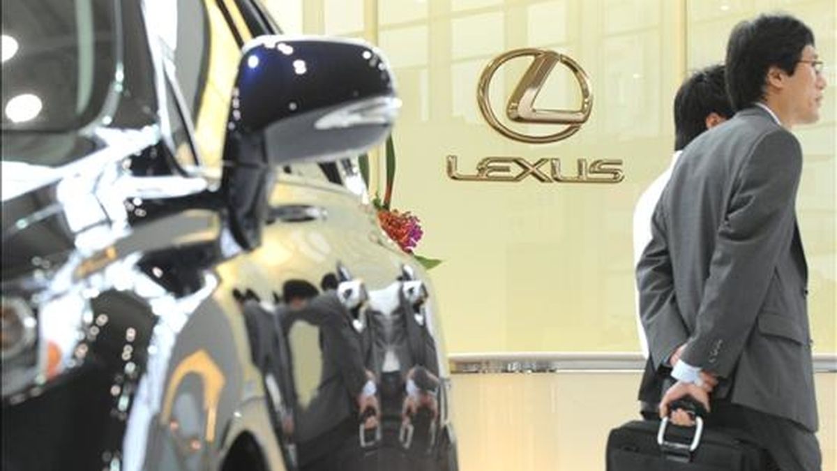 Un hombre de negocios camina junto a un coche modelo "Lexus" expuesto en uno de los concesionarios de Toyota del centro de Tokio (Japón). EFE/Archivo