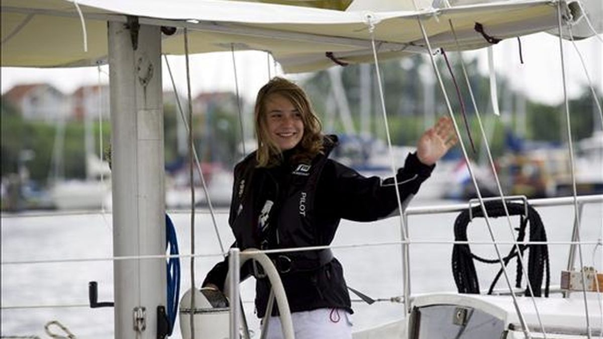 La holandesa Laura Dekker, de 14 años, se despide hoy mientras sale a bordo de su velero del puerto de Den Osse, Zeeland (Holanda). Dekker emprende hoy el viaje en el que espera convertirse en la persona más joven que consigue completar la vuelta al mundo en un barco de vela en solitario. EFE