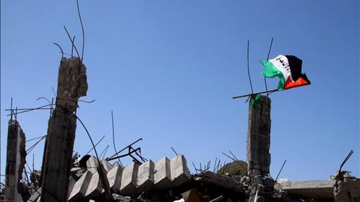 Una bandera palestina ondea en el campo de refugiados de Yabalia sobre las ruinas de una vivienda destruida durante la ofensiva israelí contra Gaza. EFE/Archivo