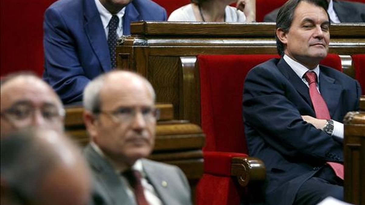 El líder de CiU, Artur Mas (d) mira de reojo al Gobierno catalán, tras la votación del documento que recoge el resultado de los trabajos de la comisión de investigación sobre las irregularidades detectadas en la gestión del Palau de la Música. EFE