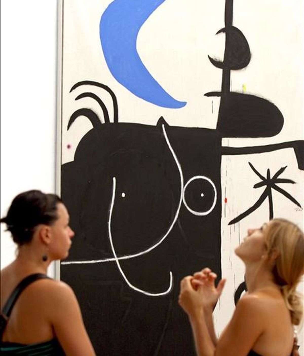 Dos jóvenes ante el cuadro "Mujer delante la lunaIl" de Joan Miró, que forma parte de la exposición "Miró-Dupin Art i poesia", que acoge la Fundación Miró de Barcelona en la que se analiza la estrecha relación y las complicidades que mantuvieron el artista mallorquín y el poeta y biográfo Jacques Dupin. EFE