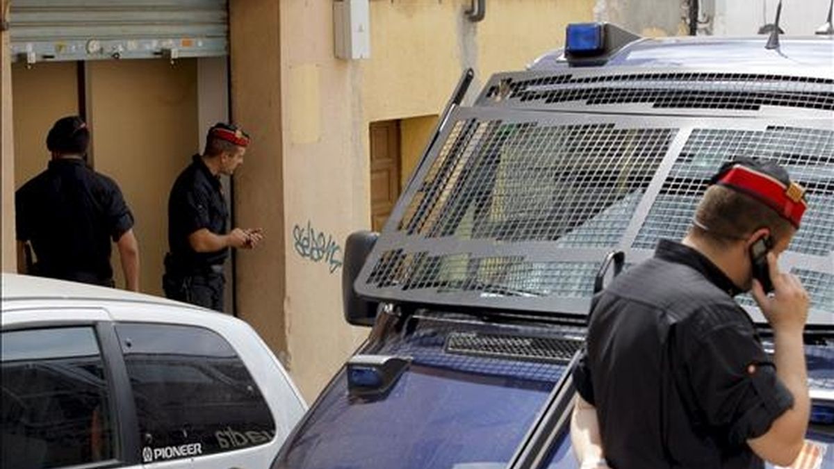 Agentes de los Mossos d'Esquadra vigilan la entrada de uno de los locales registrados durante la operación en la que se inspeccionaron unos 70 talleres clandestinos textiles regentados por ciudadanos de origen chino en Mataró (Barcelona). EFE/Archivo
