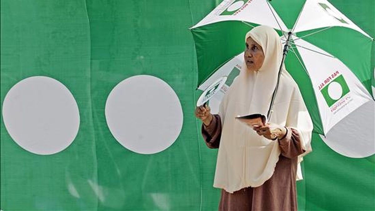UnA seguidorA del partido de la oposición Pan Partido Islámico de Malasia (PAS) permanece frente a una bandera del partido, hoy en un puesto de votación en Bukit Gantang, Taiping, a 300 Km de Kuala Lumpur. EFE