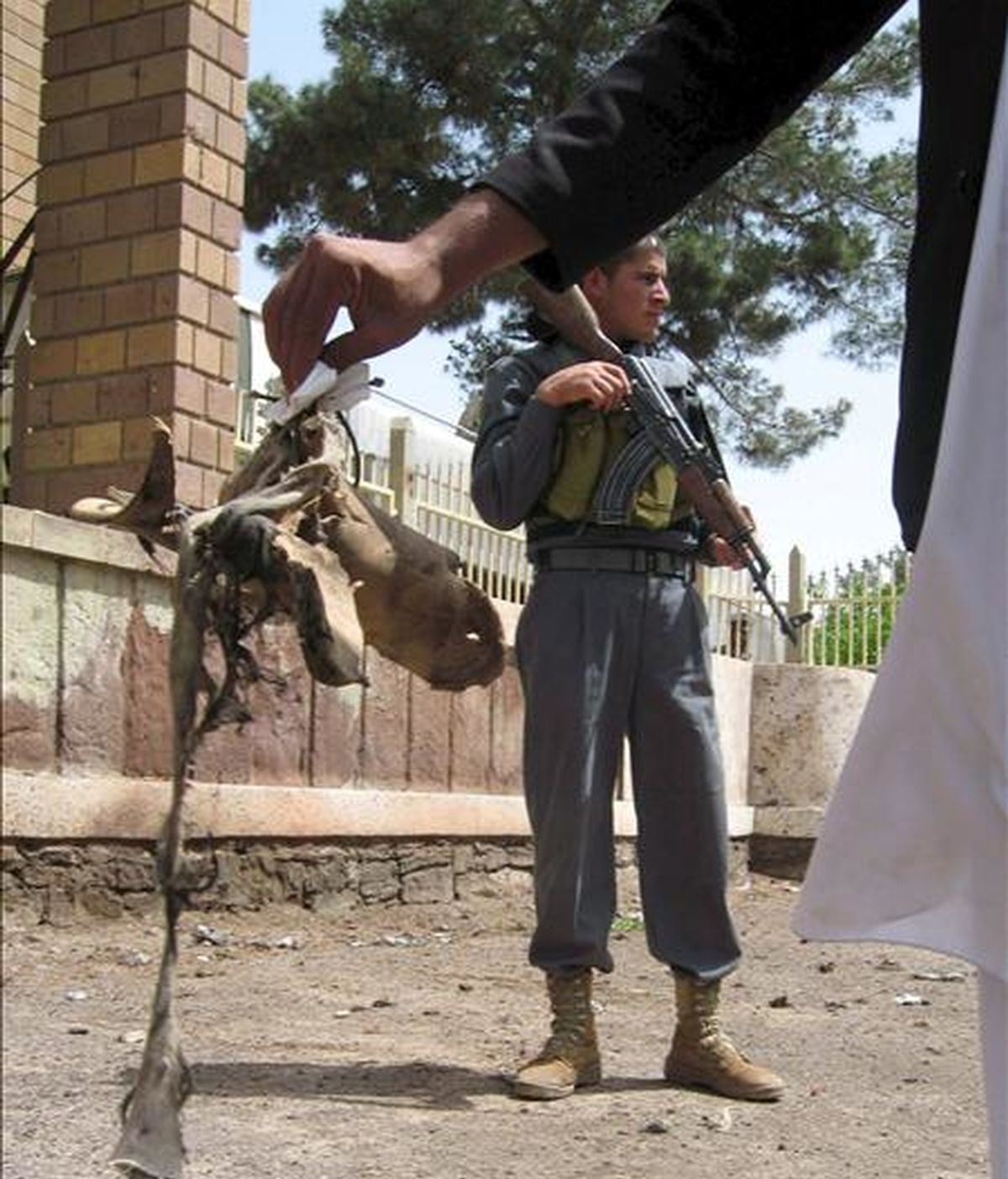 Un hombre sujeta los restos del calzado del terrorsta suicida que atentó en el complejo de las oficinas del gobernador de Herat (Afganistán), el 20 de abril de 2009. Un terrorista suicida minusválido detonó la carga explosiva que ocultaba en su pierna artificial, pero sólo murió él. EFE