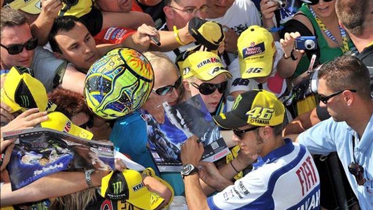 El italiano Valentino Rossi (2-d) firma autógrafos a sus fans en el circuito Sachsenring en Hohenstein-Ernstthal, donde este domigo se disputa el Gran Premio de Alemania, hoy, viernes, 16 de julio de 2010. EFE