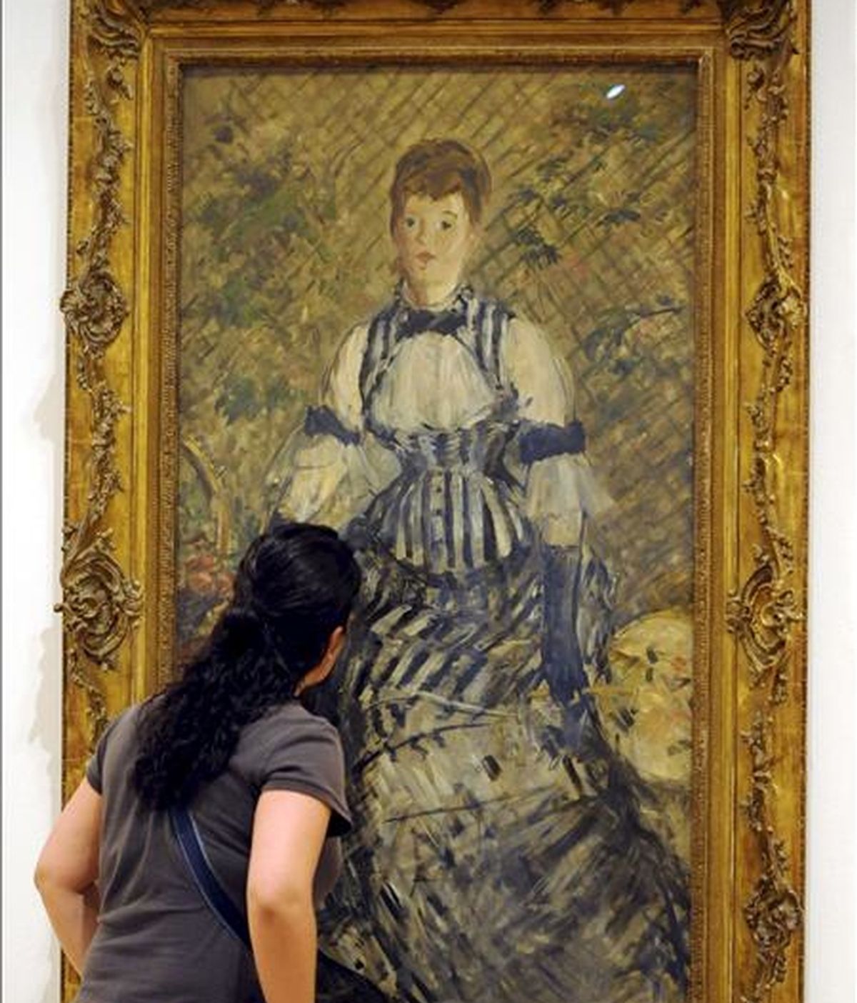 Una mujer observa la pintura "Dama en traje de noche", 1877-80, de Edouard Manet, de la exposición "De lo privado a lo público: las colecciones Guggenheim", una muestra que refleja en un centenar de obras la evolución de la colección permanente de la Fundación Solomon R.Guggenheim. EFE