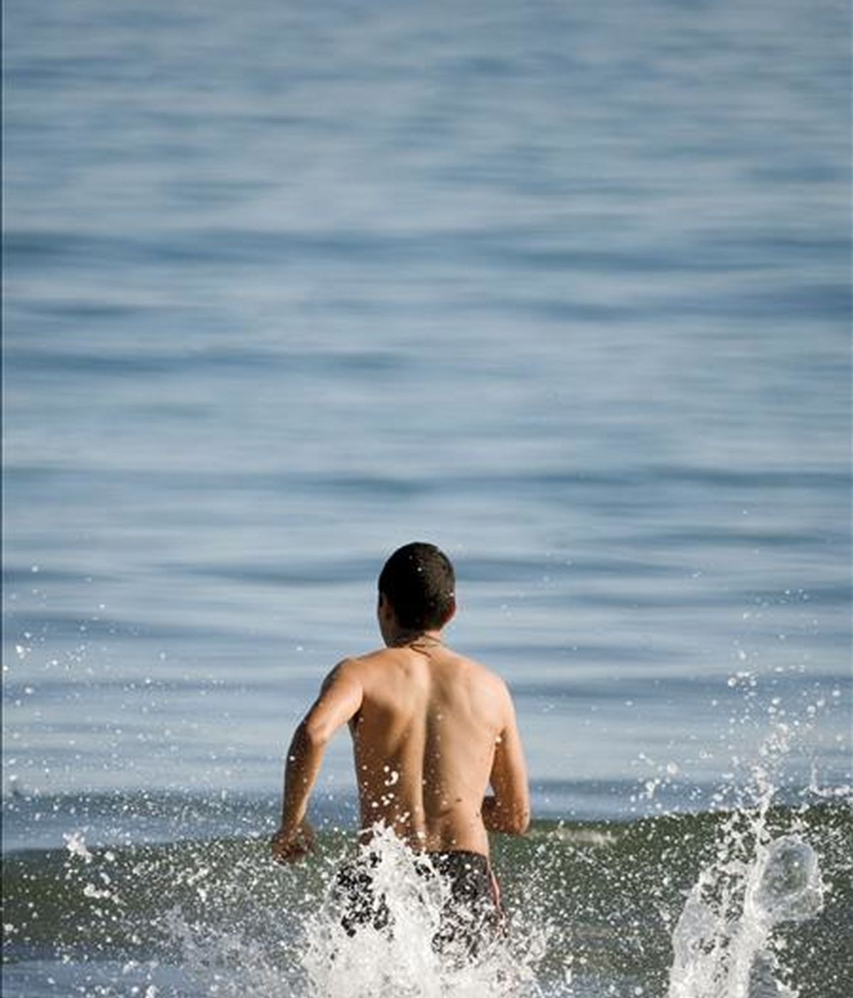 Un joven se lanza al agua en la playa de la Malvarrosa, en Valencia. EFE/Archivo