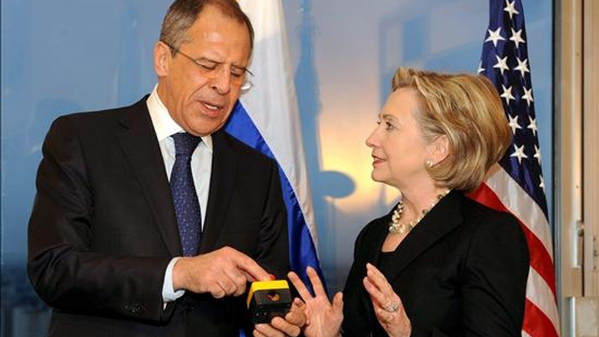 La secretaria de Estado estadounidense, Hillary Clinton (d), y el ministro de Asuntos Exteriores ruso, Sergey Lavrov, charlan después de que Clinton hiciera entrega a Lavrov de un artefacto con un botón rojo durante la reunión que mantuvieron en el hotel Continental de Ginebra (Suiza), el pasado 6 de marzo. EFE/Archivo