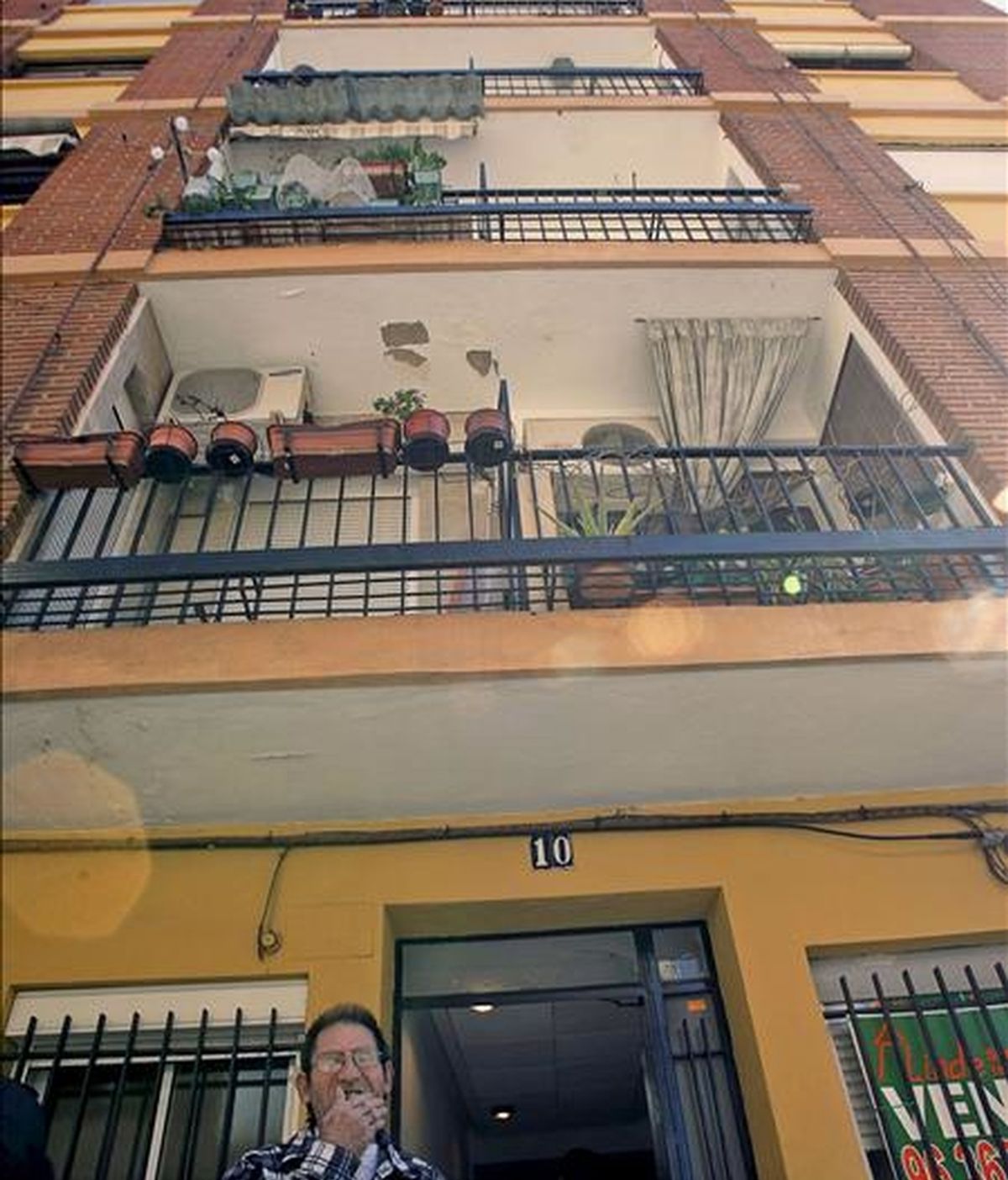 Un vecino permanece en el exterior del inmueble de Burjassot (Valencia), donde un hombre de 58 años ha asfixiado a su hermana, de 57, y después se ha suicidado. EFE