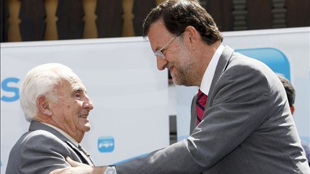 El presidente del PP, Mariano Rajoy (d), saluda al alcalde de la localidad abulense de Cuevas del Valle, Licinio Prieto (i), durante el homenaje que ha recibido por ser, a sus 87 años, el alcalde más viejo de España. EFE