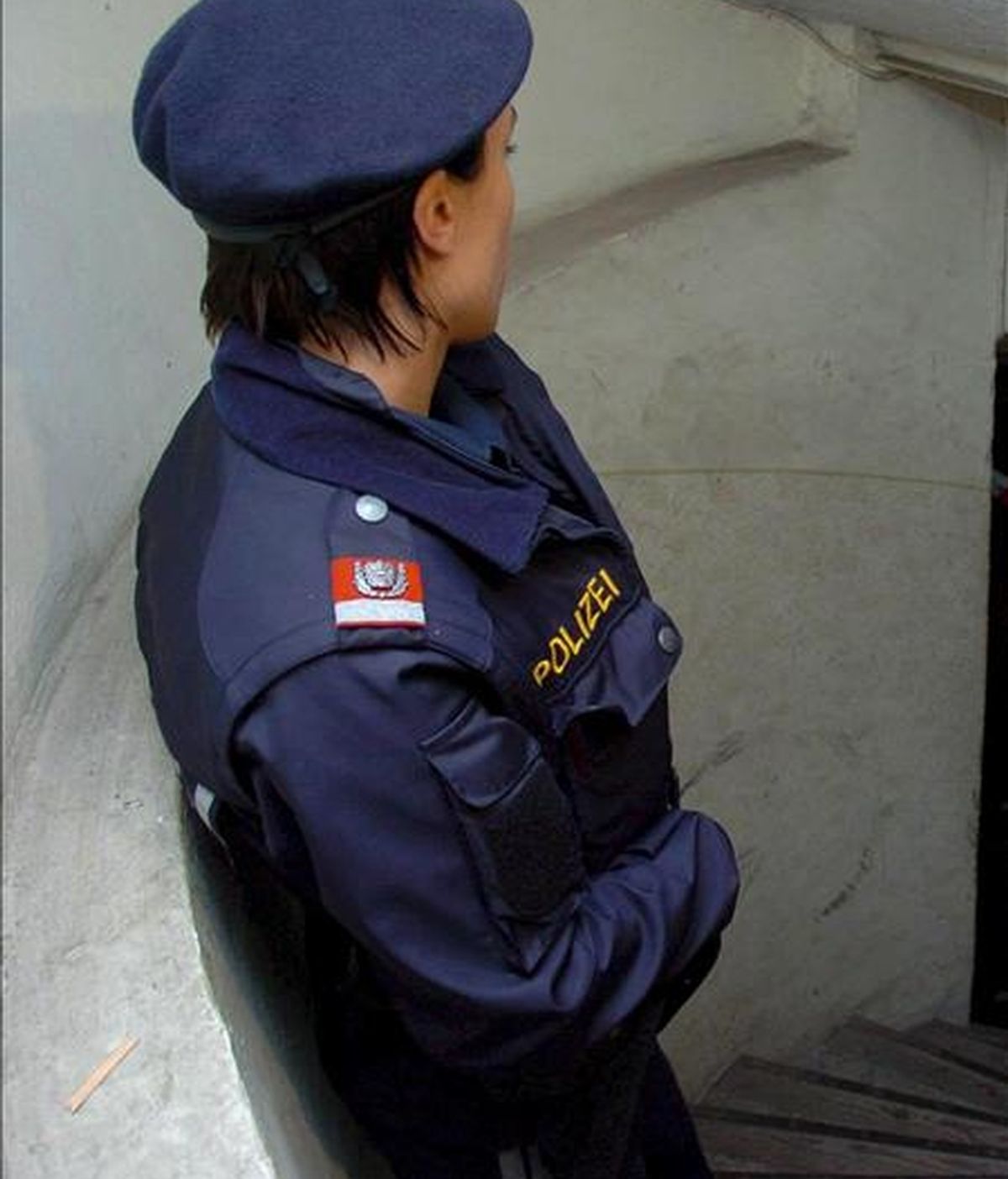 Una agente de policía monta guardia en una vivienda en Austria. EFE/Archivo