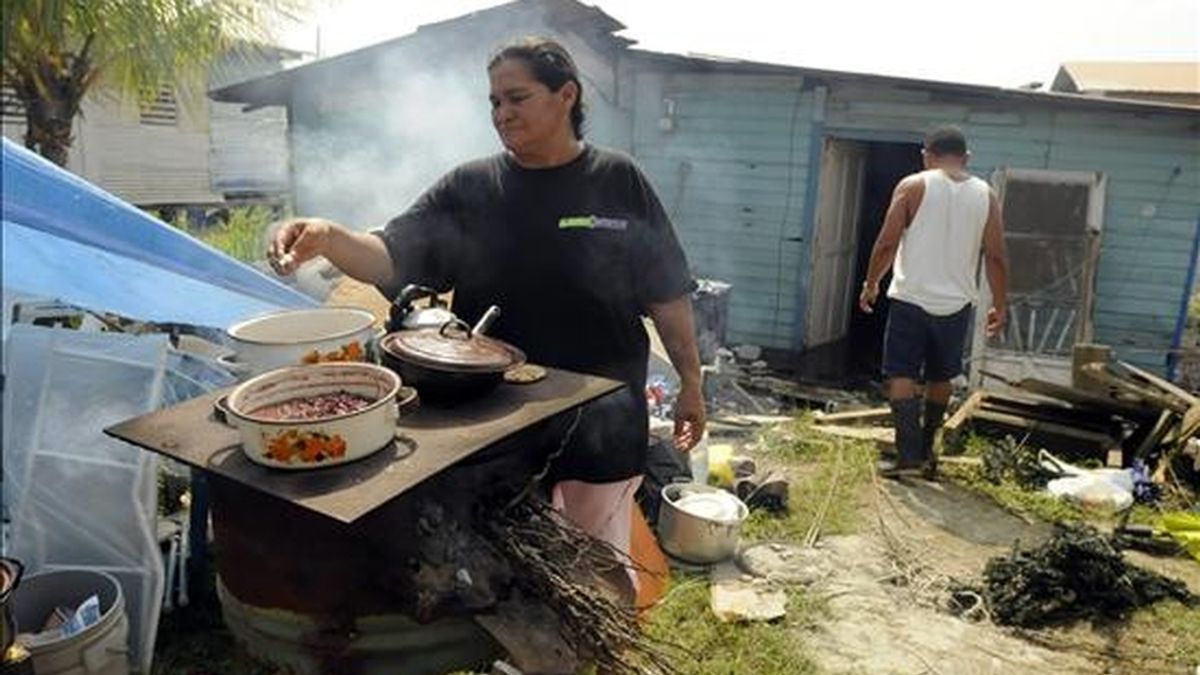 Una mujer prepara la comida fuera de su casa, afectada por el terremoto que hace una semana sacudió el norte de Honduras. EFE/Archivo