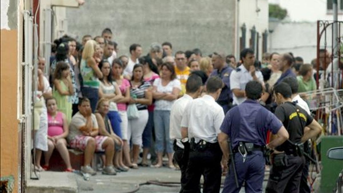Varios miembros de la Policía junto al cadáver de una mujer que ha fallecido en un incendio registrado hoy en una vivienda de La Línea de la Concepción (Cádiz), en el que otras dos personas han resultado heridas, una de ellas una niña. EFE