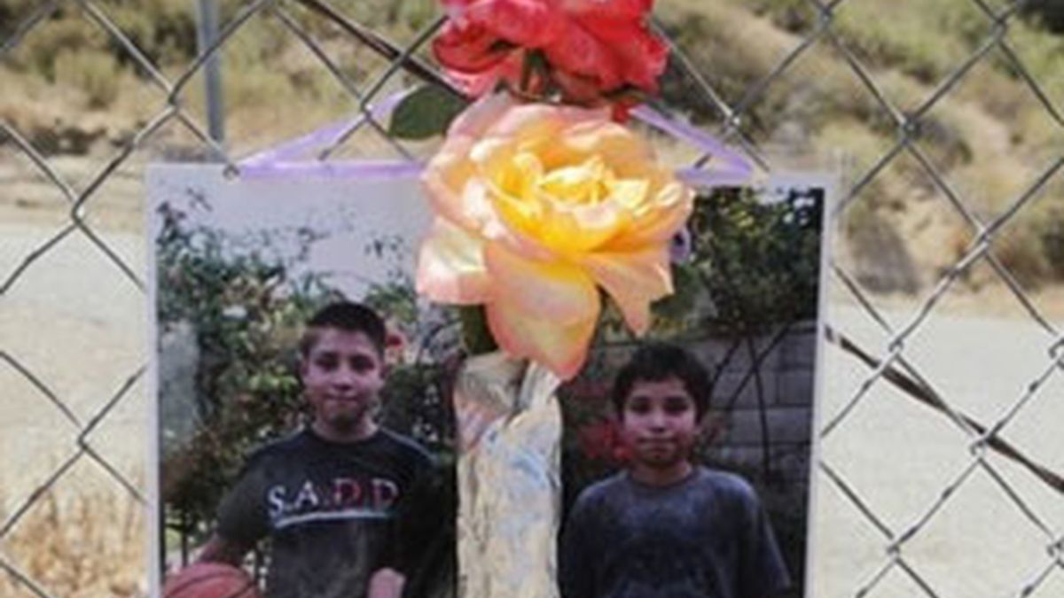 Las fotos de Bryan y Christian González junto a unas flores en el lugar donde encontraron sus cuerpos. Foto: AP