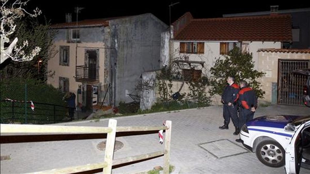 Dos ertzainas permanecen frente a la casa (al fondo) donde esta tarde ha aparecido el cadáver de un hombre de 45 años, con evidentes signos de violencia, en su domicilio del municipio vizcaíno de Zierbena. EFE