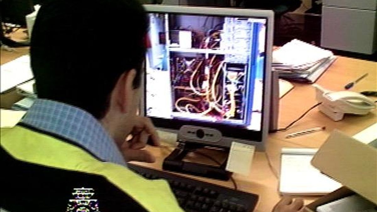 Un miembro de la policía registra un ordenador en un caso de corrupción de menores. EFE/Archivo