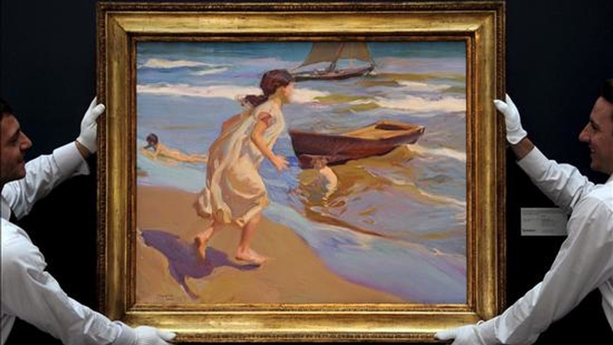 En la imagen de archivo, unos empleados de la casa de susbastas Sotheby's cuelgan el cuadro "Niña entrando en el baño", del pintor español Joaquín Sorolla, fechado en 1917. EFE