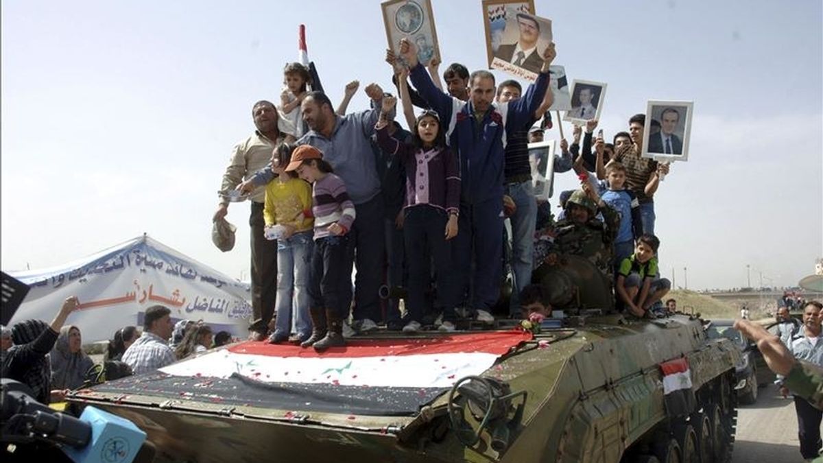 Fotografía facilitada el viernes 6 de mayo por la agencia oficial de noticias siria SANA que muestra a residentes de la localidad siria de Deraa subidos a un tanque durante una protesta. EFE/Archivo