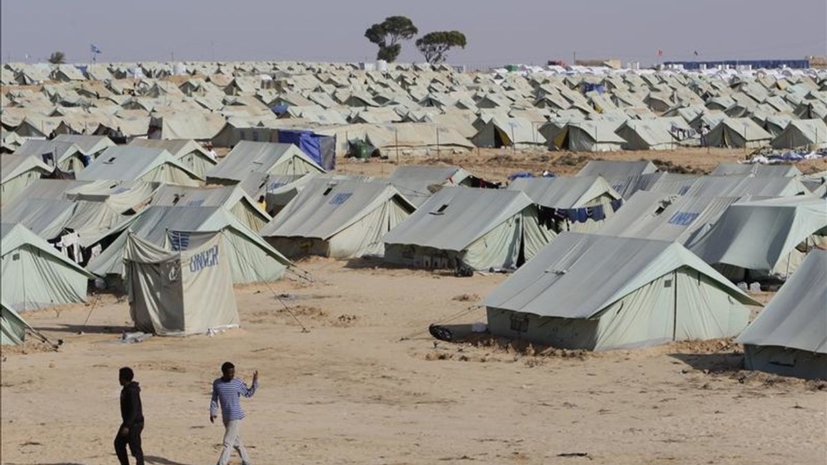 Dos hombres caminan cerca a las tiendas del campo de refugiados Bouchoucha ubicado a algunos kilómetros de la frontera con Libia, en Ras Jedir (Túnez). EFE