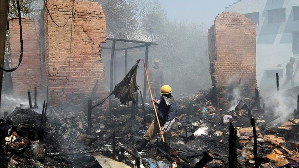 Un bombero remueve los escombros de un incendio en la Cachemira India, el pasado sábado 23 de abril de 2011. EFE/