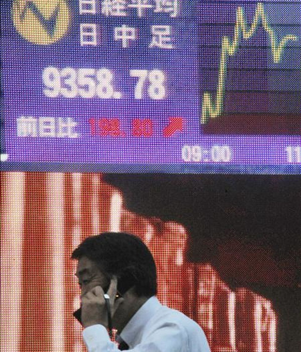 Un ejecutivo camina junto a una pantalla informativa de la bolsa en Tokio (Japón). EFE/Archivo