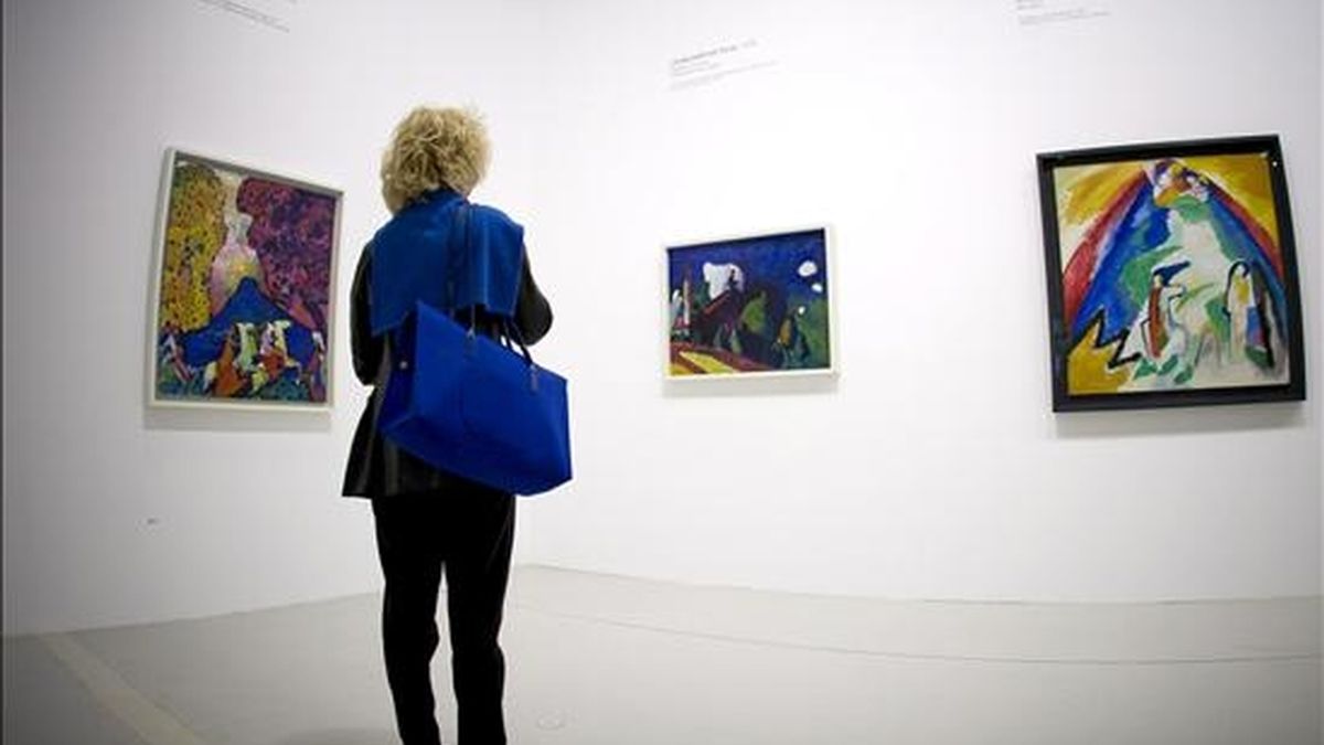Una mujer observa los trabajos "Montaña Azul", (i), "Paisaje con Torre", (c), y "Montaña", (d), del artista ruso Vassily Kandinsky que están expuestos en el centro Pompidou de París (Francia). EFE/Archivo