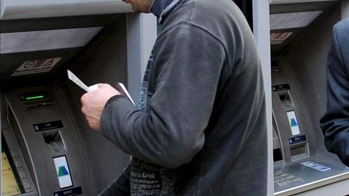 Clientes sacan dinero en un cajero automático. EFE/Archivo