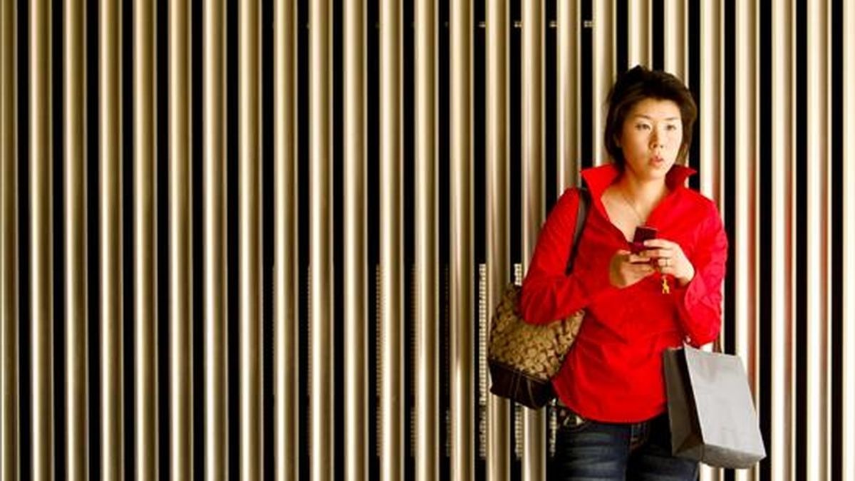 Una mujer observa su teléfono móvil en un edificio del centro de Tokio, Japón. EFE/Archivo