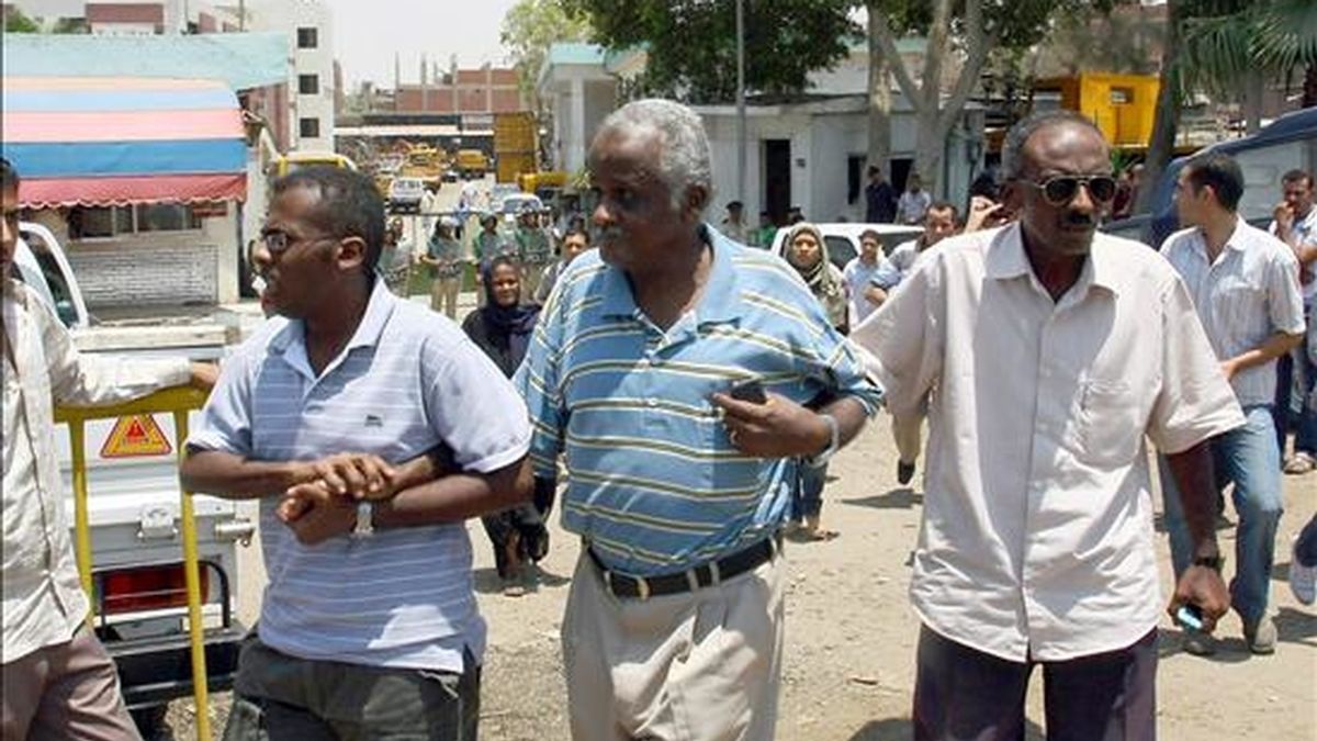 Unos amigos consolando al hermano (c) de una de las víctimas del asesinato múltiple presuntamente cometido por un conductor de autobús en un barrio de El Cairo este martes. EFE