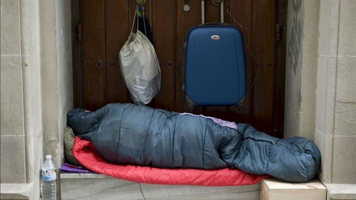 En la imagen, un indigente duerme en el portal de una vivienda. EFE/Archivo
