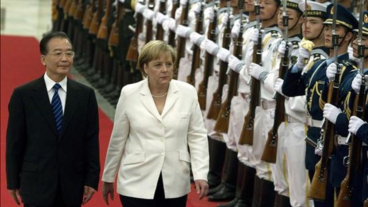 El primer ministro chino, Wen Jiabao (i), y la canciller alemana, Angela Merkel (c), pasan revista a las tropas durante una ceremonia en el Gran Salón Popular de Pekín.EFE