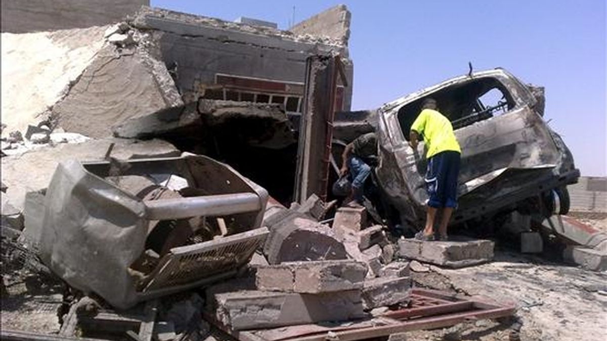 Dos niños iraquíes observan los restos de un vehículo y de una casa tras la explosión de una bomba, el pasado 8 de julio en Ramadi. EFE/Archico