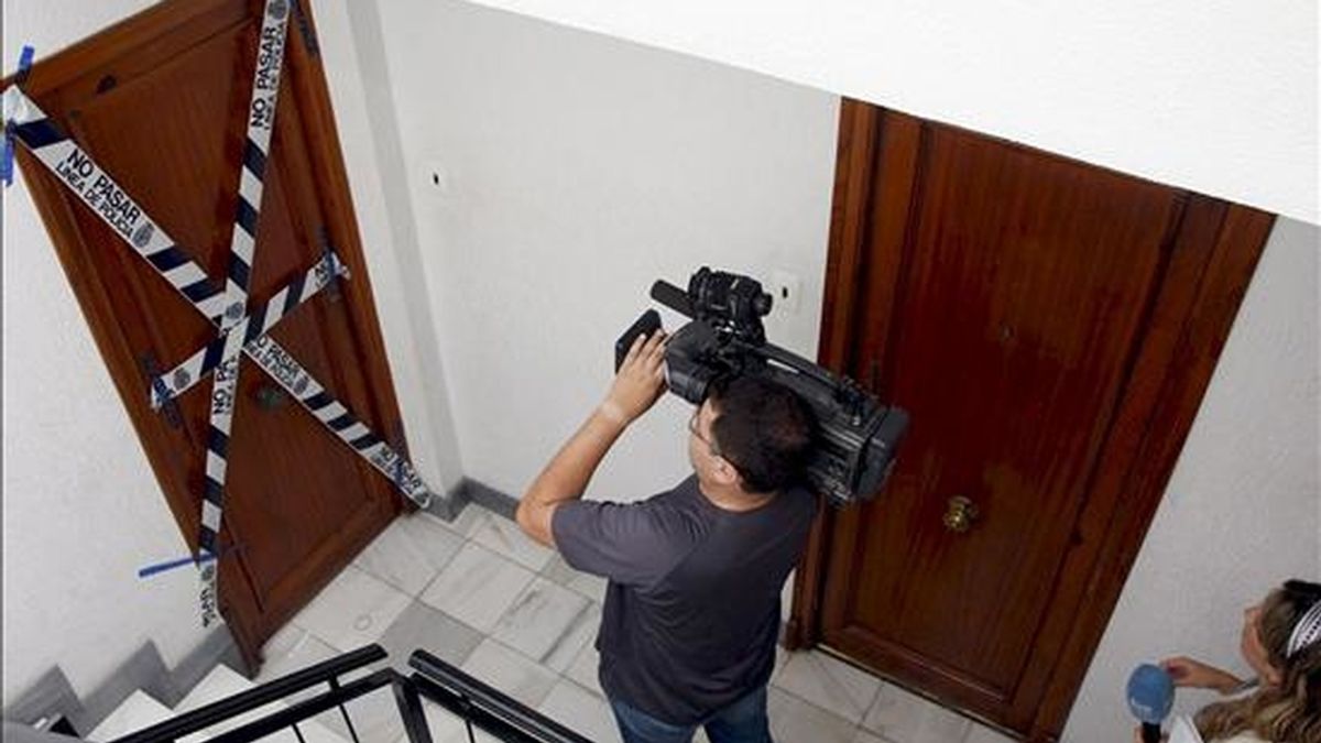 Un reportero de televisión toma imágenes de la vivienda que la Policía Nacional mantiene precintada dónde vivía la mujer que ayer apareció descuartizada en varios contenedores de una céntrica calle de la ciudad de Elche. EFE