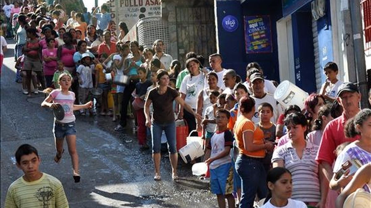 Varios habitantes del barrio Comuna 13 de Medellín (Colombia) hacen fila para recibir leche gratuita. Las personas de esta zona, en su mayoría desplazados por la violencia, carecen habitualmente de este suplemento alimenticio y sus hijos sufren de desnutrición. EFE/Archivo