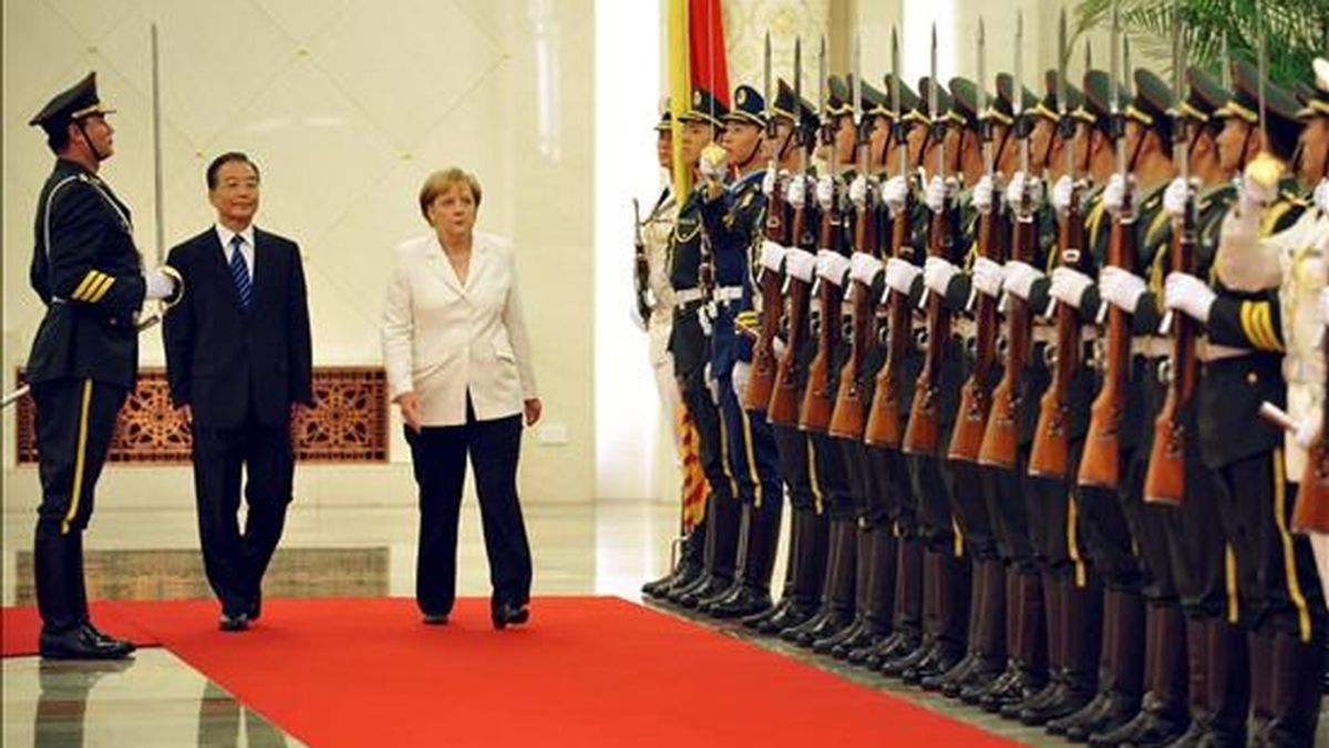 El primer ministro chino, Wen Jiabao (i) y la canciller alemana, Angela Merkel (d), pasan revista a la guardia de honor durante una reunión en el Gran Palacio del Pueblo en Pekín, China, hoy, viernes 16 de julio de 2010. Merkel realiza una visita oficial a China. EFE