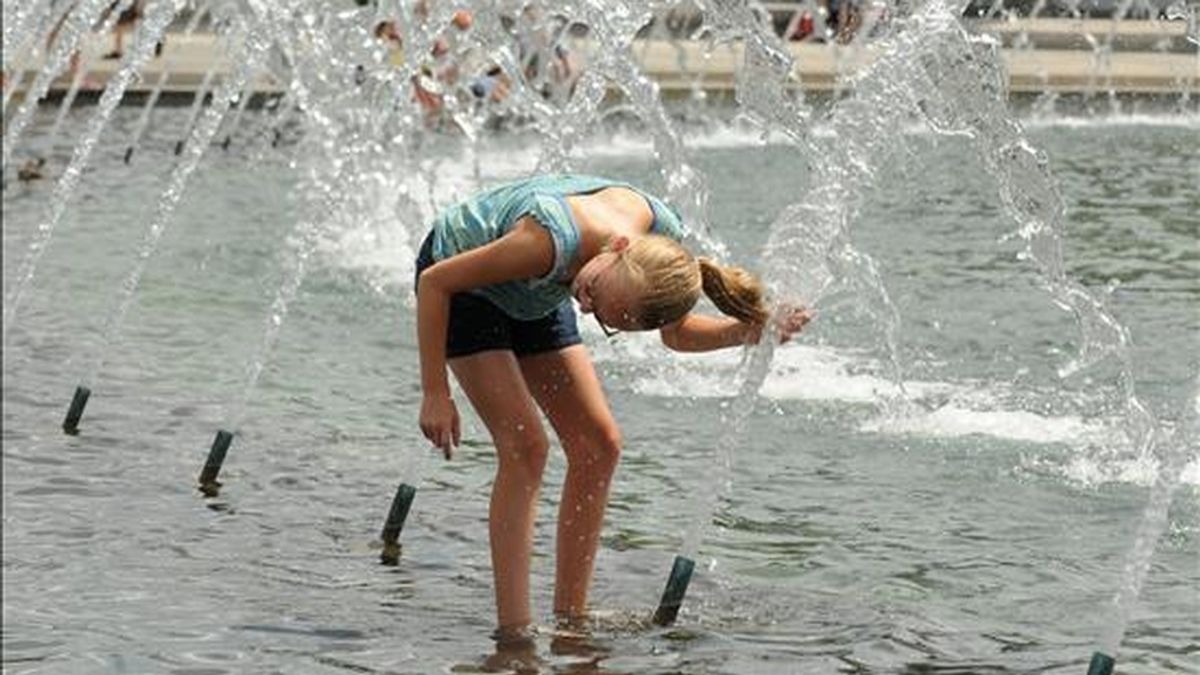 Una joven se refresca en una fuente por las altas temperaturas. EFE/Archivo