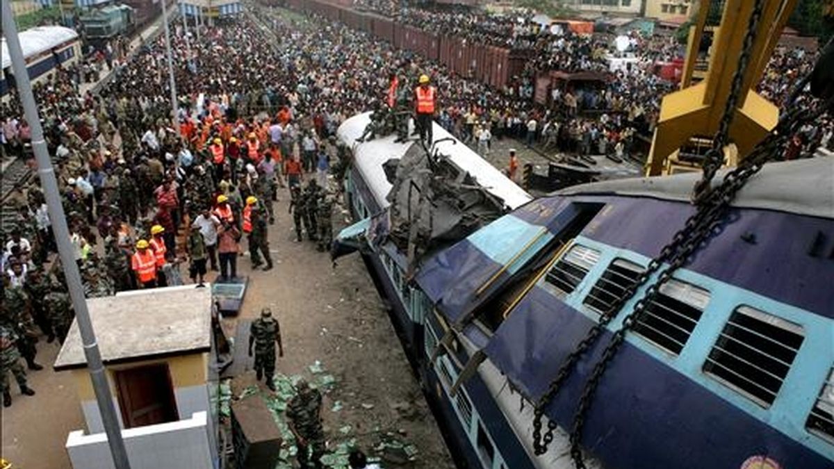 Soldados indios y miembros de los equipos de rescate trabajan en el lugar del choque de un tren de pasajeros que se dirigía a Calcuta contra otro que estaba detenido en una estación ferroviaria del Estado nororiental indio de Bengala, este lunes. EFE
