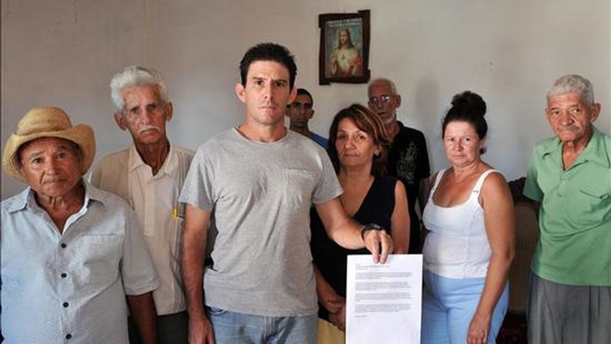El disidente cubano Silvio Benítez (c), activista de la "Red Ciudadana Voces del Barrio", y otros opositores al Gobierno posan mostrando una copia de la carta enviada a la Asamblea Nacional. EFE
