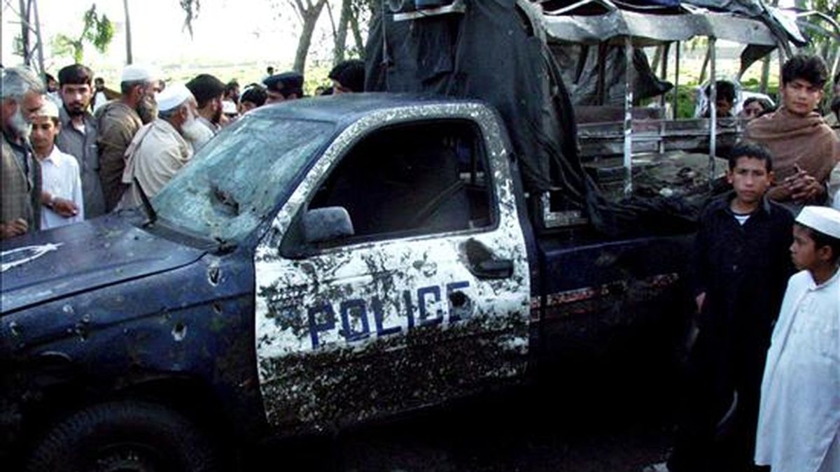 Varias personas observan los restos de un vehículo tras un atentado suicida en un puesto de control en el distrito de Charsada, situado en la Provincia de la Frontera del Noroeste (NWFP) en Pakistán, el pasado 16 de abril. EFE/Archivo