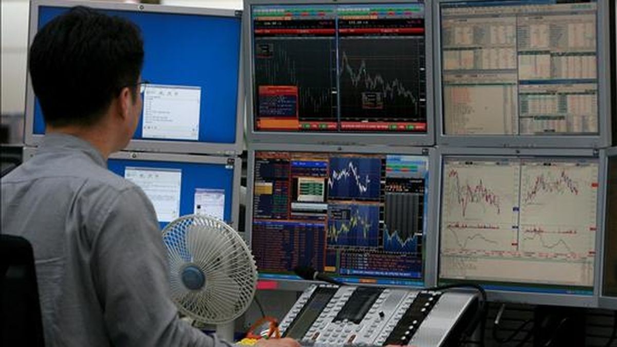 Un hombre observa un panel con las divisas y la cotización de la bolsa en Seúl. EFE