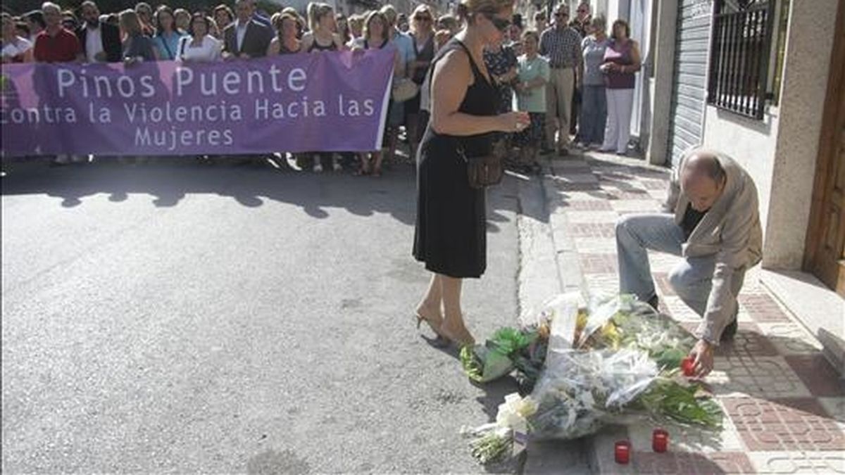 Algunos de los participantes este viernes en una manifestación en la localidad granadina de Pinos Puente depositando flores en el lugar donde este viernes una mujer de 42 años murio, presuntamente agredida por su ex pareja. EFE