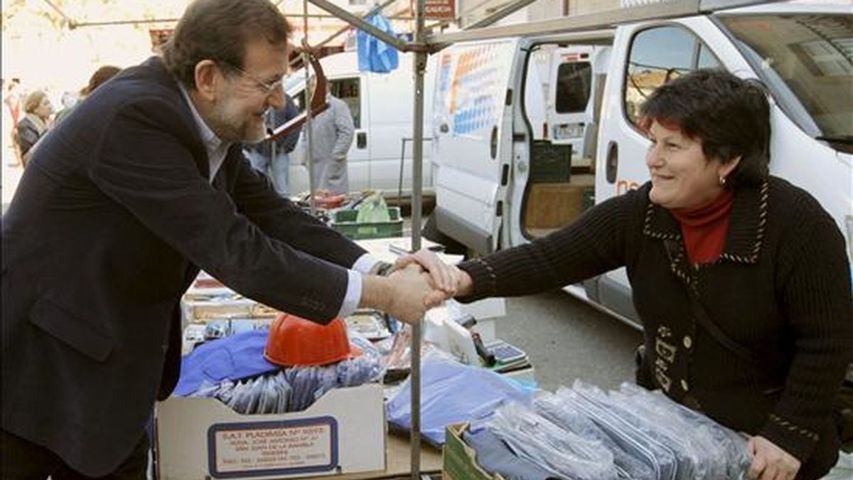 El presidente del Partido Popular, Mariano Rajoy, saluda a una venderora durante una visita a un mercadillo pontevedrés en febrero de 2009. EFE/Archivo
